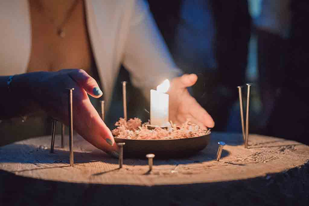 Gäste beim traditionellen Nagelschlagen bei Kerzenlicht im stettli resort