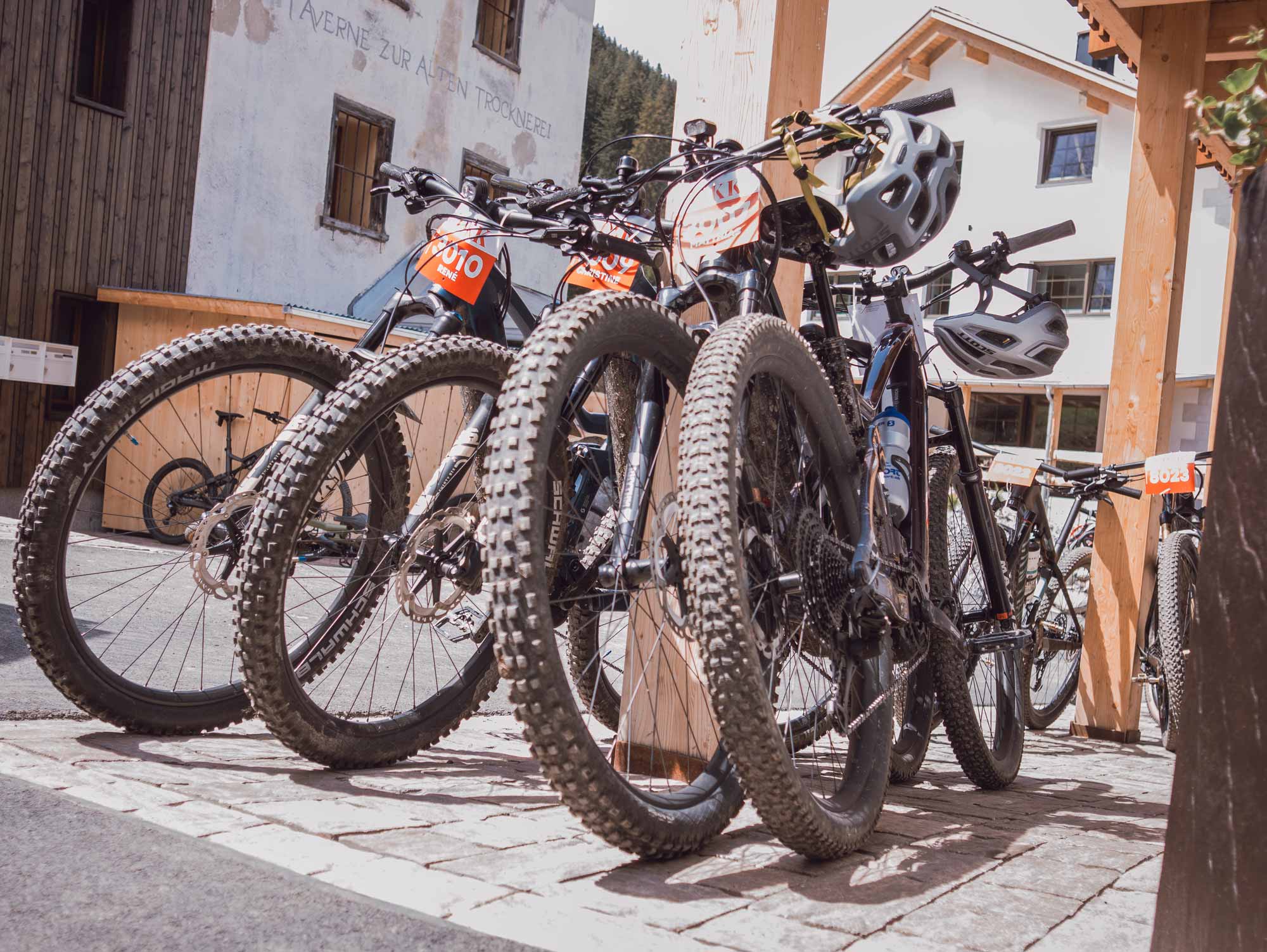 Mehrere Mountainbikes mit auffälligen Startnummern stehen parkend vor dem stettli resort Lenzerheide